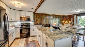Eine moderne Küche mit weißen Schränken, einer Granitabdeckung und Holzvertäfelung an den Wänden.