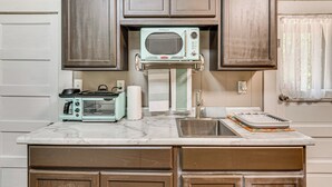 A compact kitchen with a built-in microwave, toaster, and sink. - Hot Tub + Deck: Cabin Hideaway in Brown County (Nineveh)