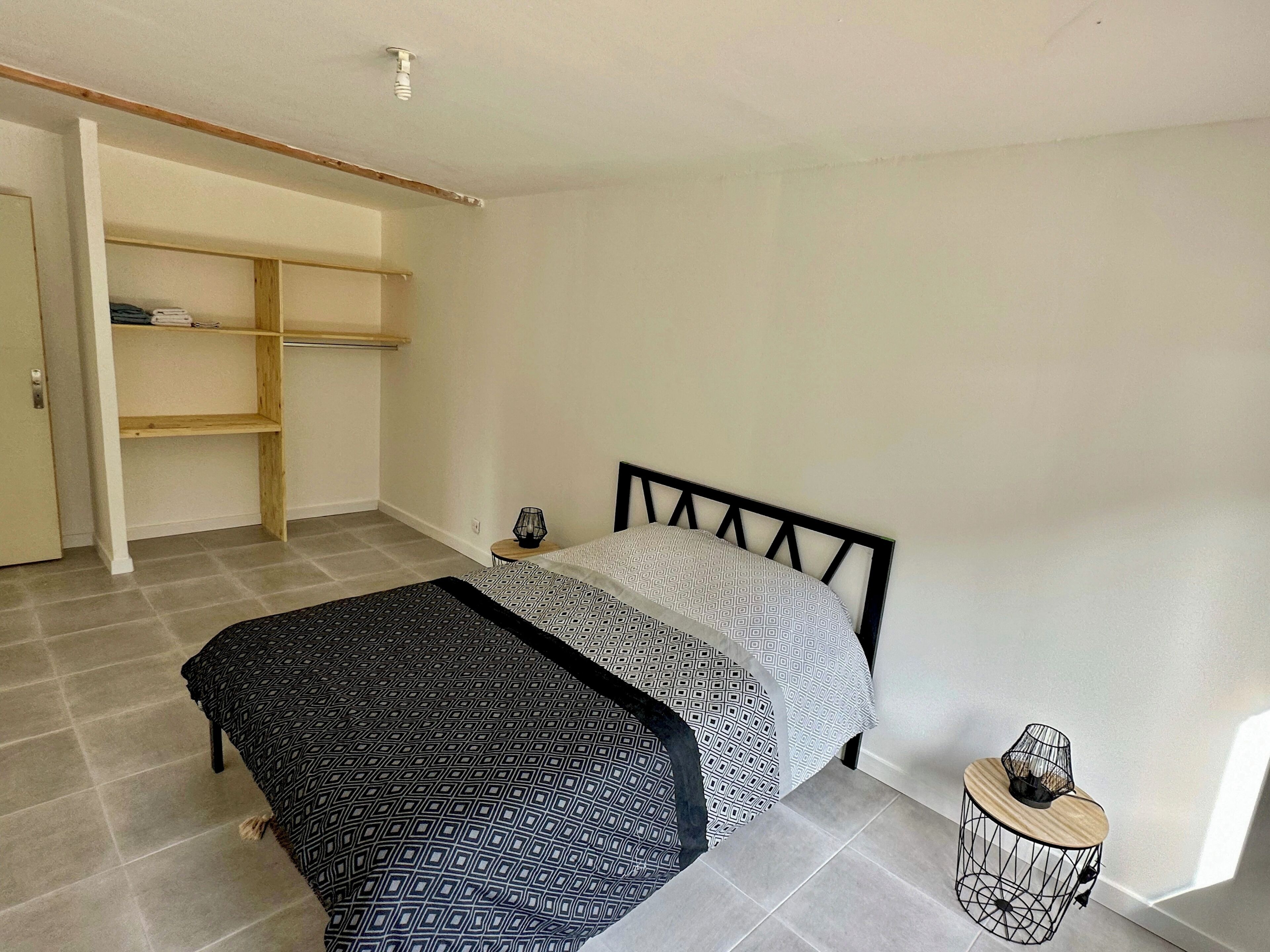 Une chambre à coucher avec un lit, une armoire et une petite table de chevet.