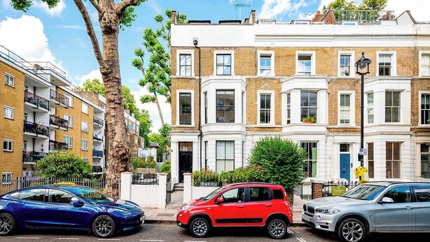 A row of terraced houses with a tree in the foreground, parked cars, and a clear blue sky. - The Light Chambers Notting Hill- by Out of Office Lifestyle (London)