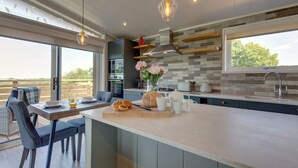 A modern kitchen with a large island, built-in appliances, and a view to the outdoors.