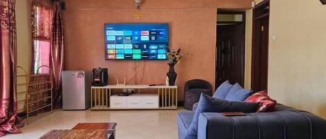 Familie bungalow, uitzicht op tuin | Woonruimte | Een 32-inch smart-tv met digitale zenders en een dvd-speler