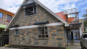 Un bâtiment en pierre de deux étages, doté d’un toit en pente, de nombreuses fenêtres et d’une allée pavée.