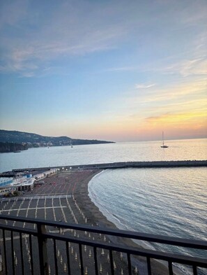 Una vista costiera con spiaggia, molo e tramonto.