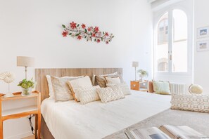 Een slaapkamer met een groot bed, houten hoofdbord en een decoratieve wandversiering.
