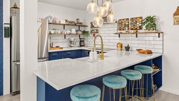 A modern kitchen with a white island, blue cabinets, and gold fixtures. - Remodeled Snowmass Pet-Friendly Modern 1BR Condo - G125 (Snowmass Village)