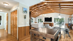 A spacious kitchen with wooden cabinets, a dining table, and a chandelier. - Old Seagrove "Angel's Share" 4BR | Sleeps 10 | Heated Pool | Updates | 🐶 (Santa Rosa Beach)