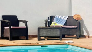 A swimming pool with lounge chairs and a bottle of wine.