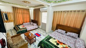 A hotel room with two beds, a small table, a chair, a wardrobe, and a window with curtains. - Hotel zam Zam Residential (Dhaka)