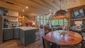 A spacious kitchen with wooden cabinets, a large island, and a dining area with a round table and chairs.