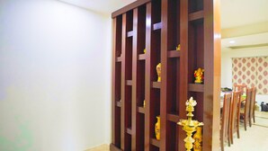 A room with a wooden partition, a dining area with chairs, and a table. - Mystic Felicity Inn (Bengaluru)