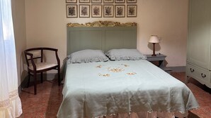 Une chambre à coucher comprenant un lit, une chaise, une table de chevet, une lampe et une armoire.