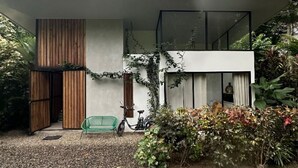 Een modern huis met een plat dak, grote ramen en een grindpad.