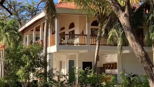 Un bâtiment à deux étages doté d’un balcon et d’un porche couvert.