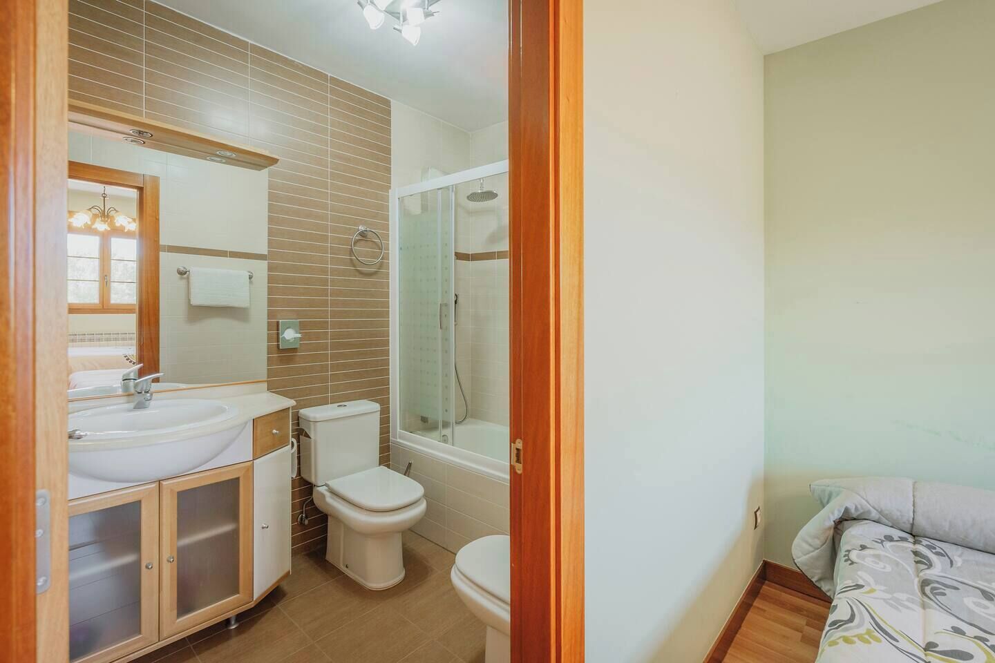 Un baño con lavamanos, dos inodoros y una ducha.