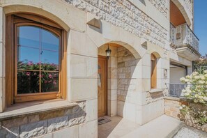 Un edificio de piedra con un amplio ventanal de arco y una puerta de madera.