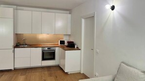 A compact kitchen with white cabinets, a microwave, a sink, and an oven. - 3 rooms equipped all comfort with swimming pool and tennis near the navigli (Milano)