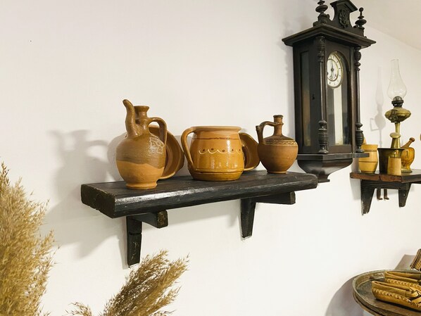 Un estante con diferentes objetos de cerámica y un reloj de pared.