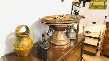 Une table en bois, un plateau en métal, une carafe en céramique et une lampe en métal.