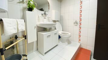 Ein Badezimmer mit Waschbecken, Toilette und Handtuchhalter.