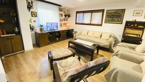 Un salon comprenant un canapé, une table basse, un téléviseur et un meuble.