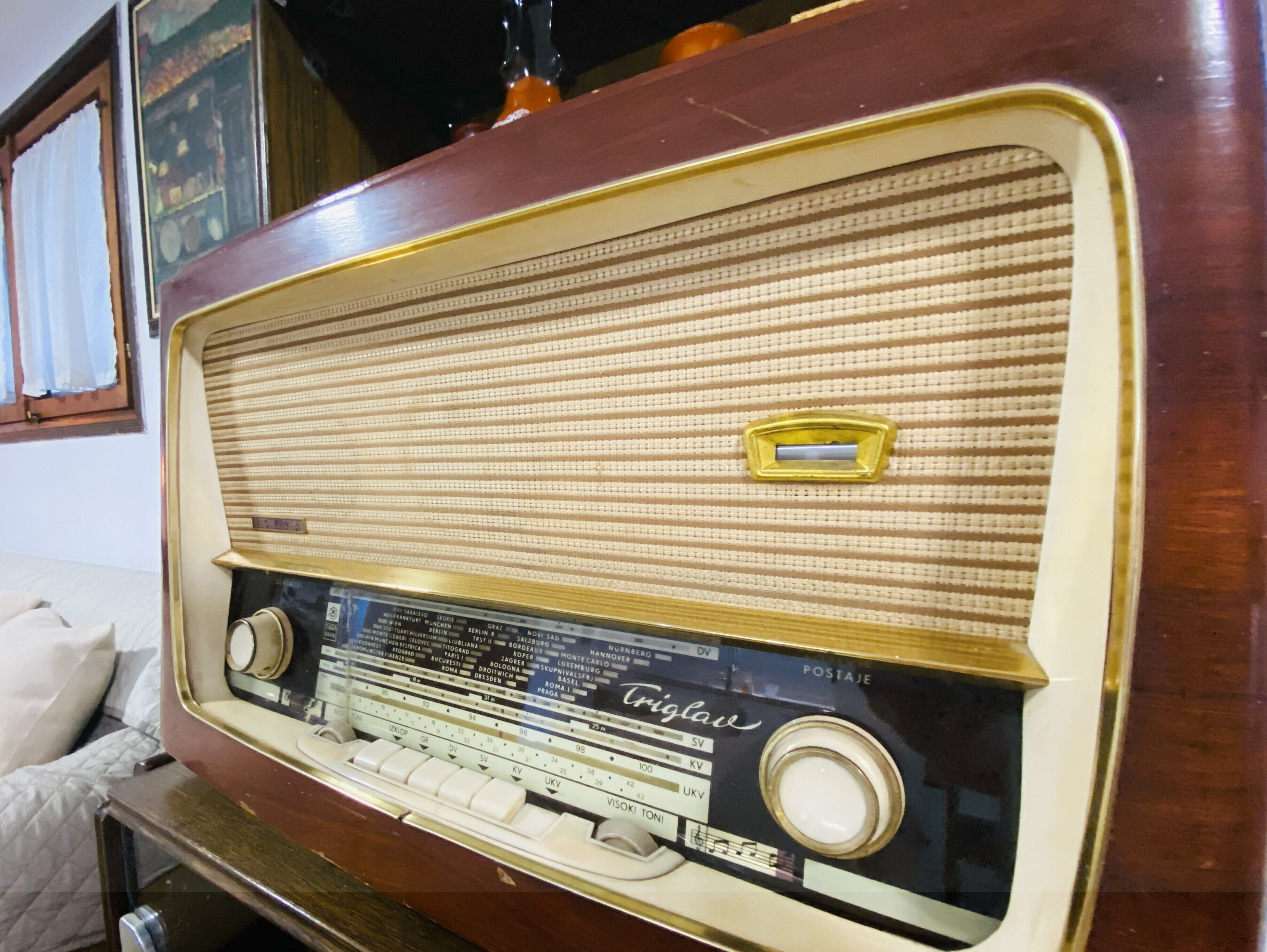 A vintage radio with a wooden cabinet and a fabric speaker grille.