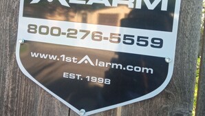 A metal sign with the text "1st Alarm" and contact information. - Charming 2-bedroom house in gorgeous Lubbock with WiFi, AC (Lubbock)