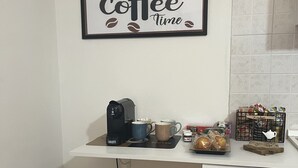 A kitchen with a coffee-themed wall art, a coffee machine, cups, and a kettle on the counter. - Accommodation you love (Molinaccio)