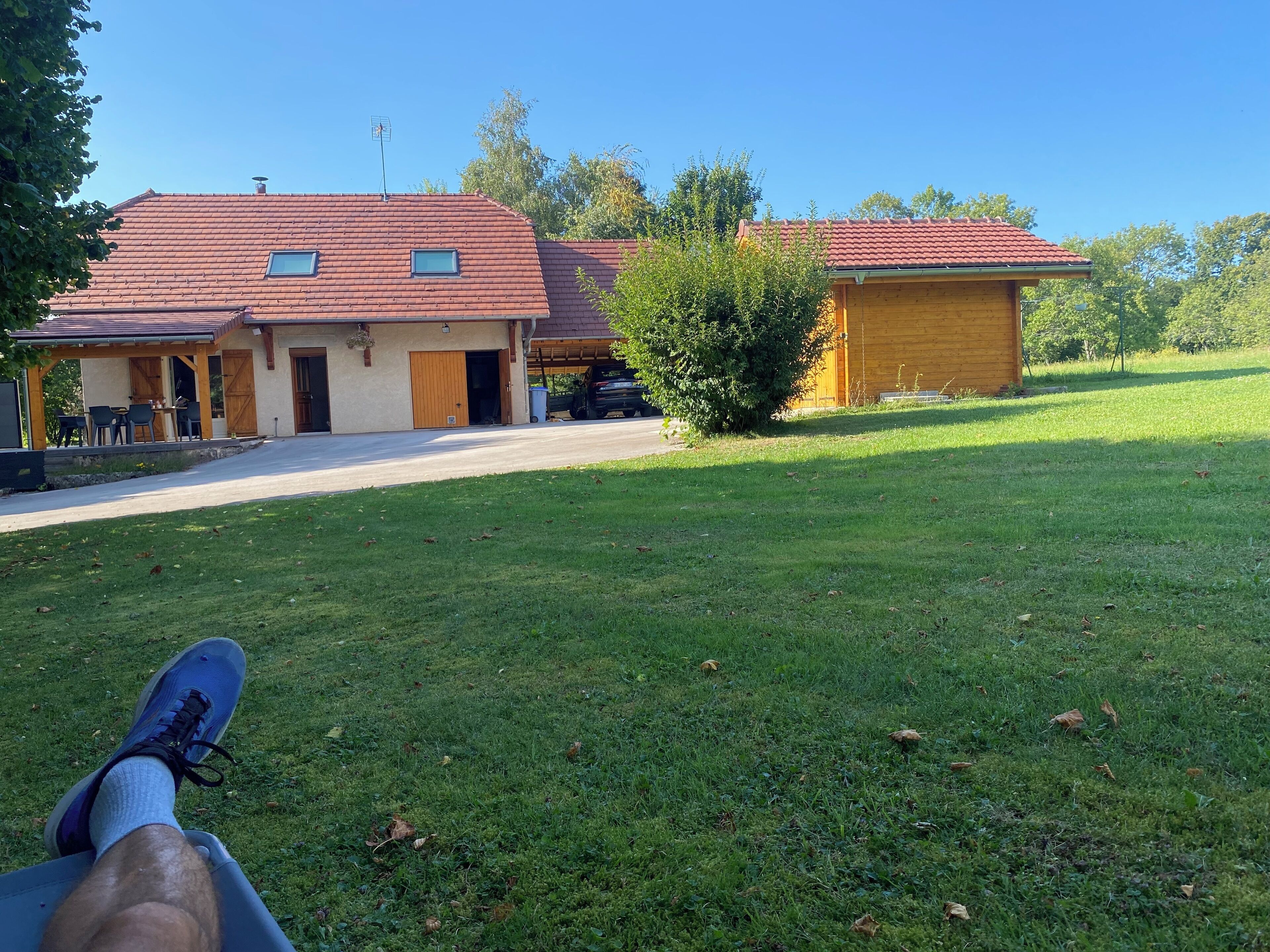 Une maison avec un toit recouvert de tuiles rouges, une véranda et un garage.