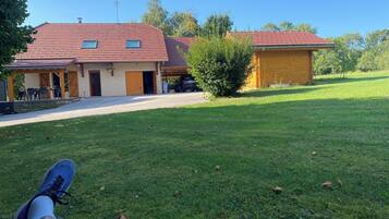 Une maison avec un toit recouvert de tuiles rouges, une véranda et un garage.