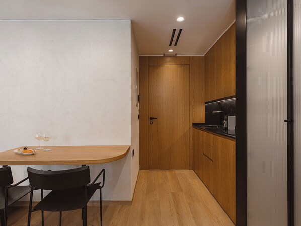 Una cocina pequeña con cubierta de madera, un lavamanos y una silla negra.