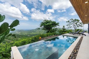 A pool with a clear view of a mountainous landscape, surrounded by lush greenery and trees. - Mountainside Home with Modern Design, Sweeping Ocean Views & Private Swimming Pool (Pacific Heights)