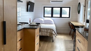 A compact bedroom with a bed, bedside table, and a window. - The Northern Tickle. 20 minutes to Twillingate. Gorgeous views of the ocean. (Summerford)