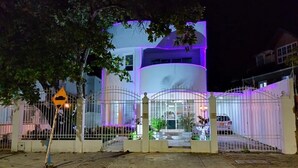 Un bâtiment moderne à la structure cylindrique, doté d’une entrée sécurisée et d’un panneau indiquant un rétrécissement de la chaussée.