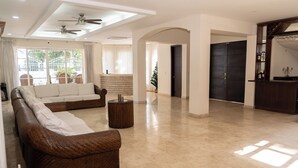 Un vaste espace de vie comprenant un canapé marron, une table basse et un ventilateur de plafond.