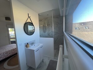 Een douche, handdoeken, zeep, toiletpapier