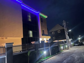 A modern building with a flat roof, large windows, and a gated entrance. - Chapy hotel and suite (Enugu)