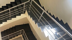 Eine mehrgeschossige Treppe mit Metallgeländern und schwarzen Stufen.