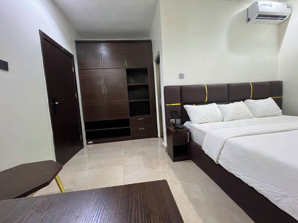 A bedroom with a bed, bedside table, and a wardrobe.