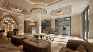 Eine geräumige Lobby mit einem prächtigen Kronleuchter, bequemen Sitzgelegenheiten und einer Rezeption.