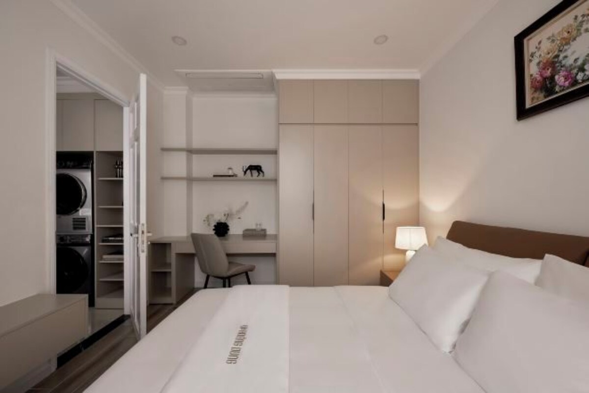 Una habitación de hotel con una cama, un escritorio y un armario.