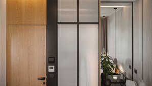 Una habitación moderna con una puerta de madera, un panel de control y una planta en maceta.