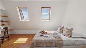 A bedroom with a loft bed, two skylights, a desk with a chair, and a small shelf. - Charming 1BR in Le Marais - Bretagne (Paris)