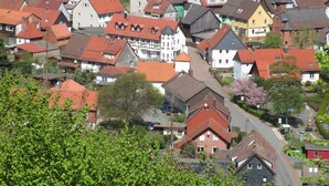 Un pueblo con casas tradicionales, calles estrechas y un paisaje de colinas al fondo.