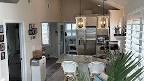 A spacious kitchen with a central island, white cabinetry, and stainless steel appliances.