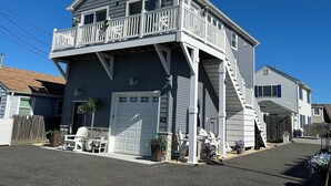 A two-story house with a balcony, a garage, and a staircase leading to the upper floor.