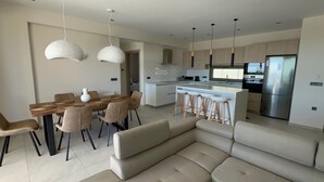 Una cocina moderna con una isla central, taburetes de bar y un horno empotrado.
