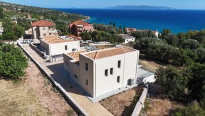 Un área residencial costera con edificios modernos, un camino pavimentado y vista al mar.