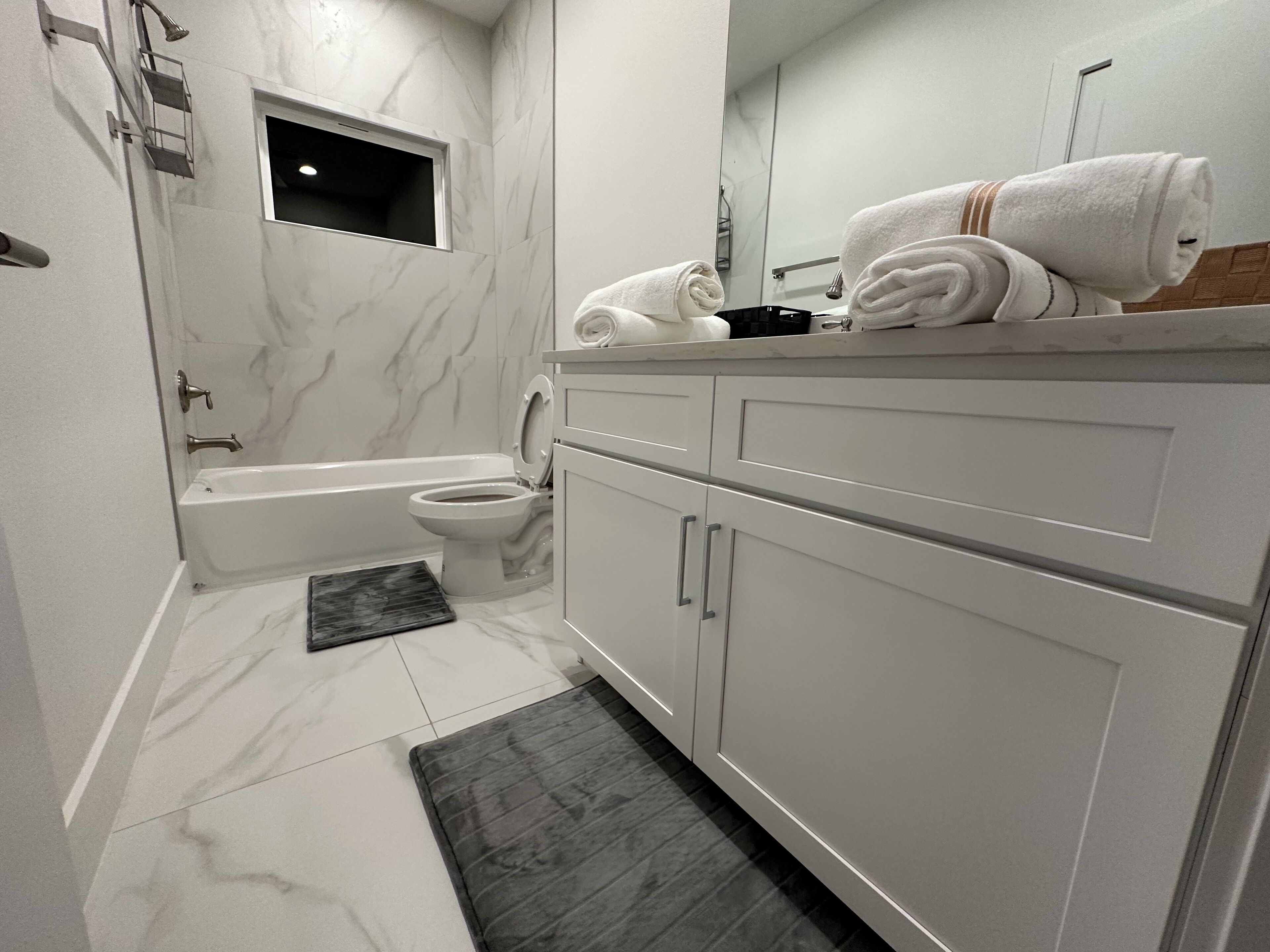 Ein modernes Badezimmer mit Badewanne, Toilette und Waschtisch mit Spiegel.