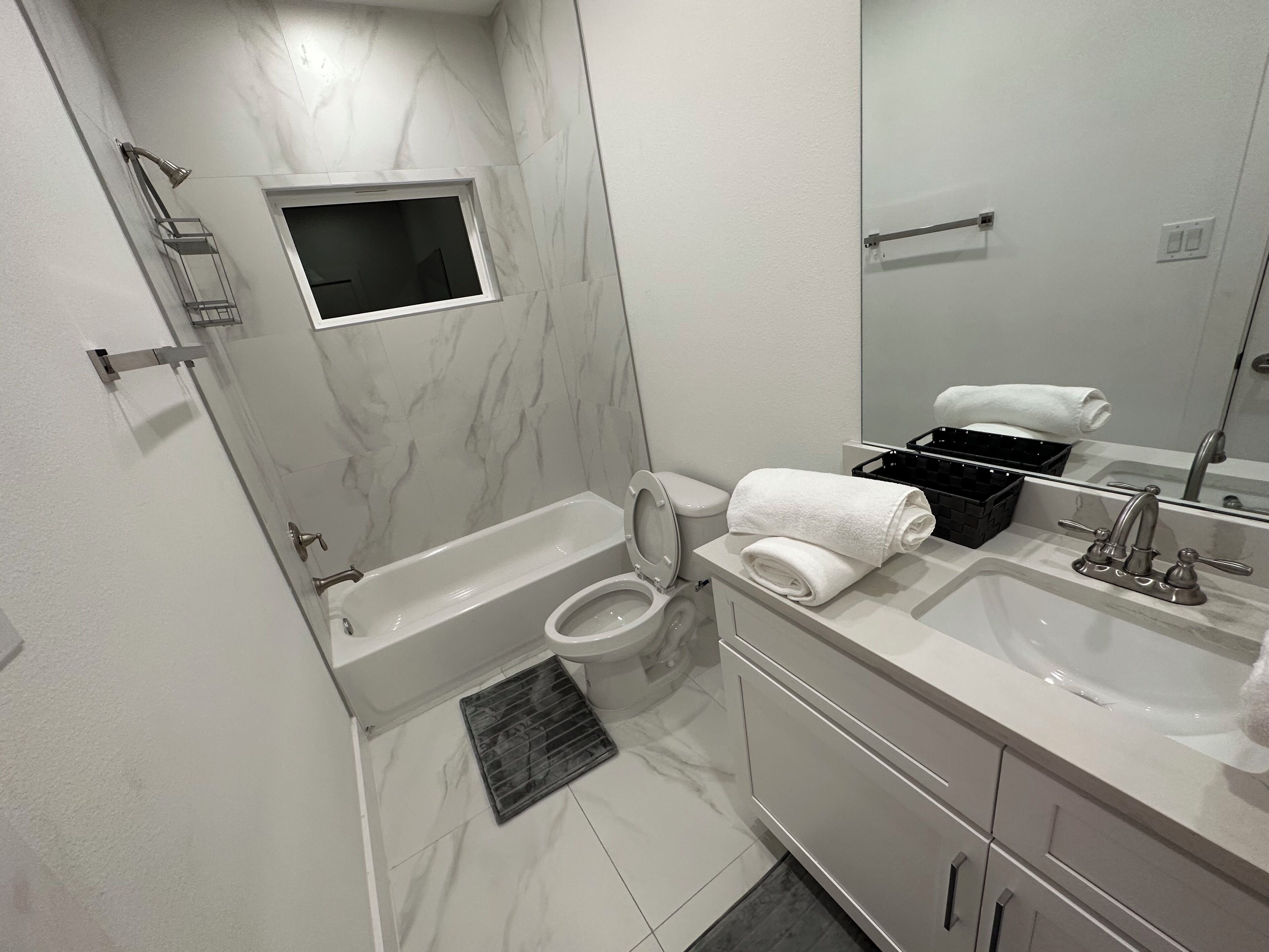 A modern bathroom with a bathtub, toilet, and sink.